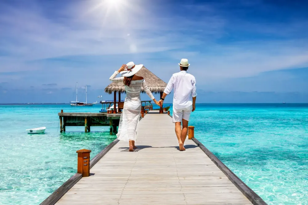 Couple walking towards an overwater bungalow